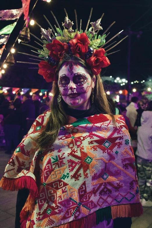 a woman with painted skin and floral wreaths on her head at a festival