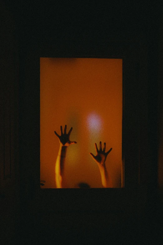 three hands are seen through an illuminated box