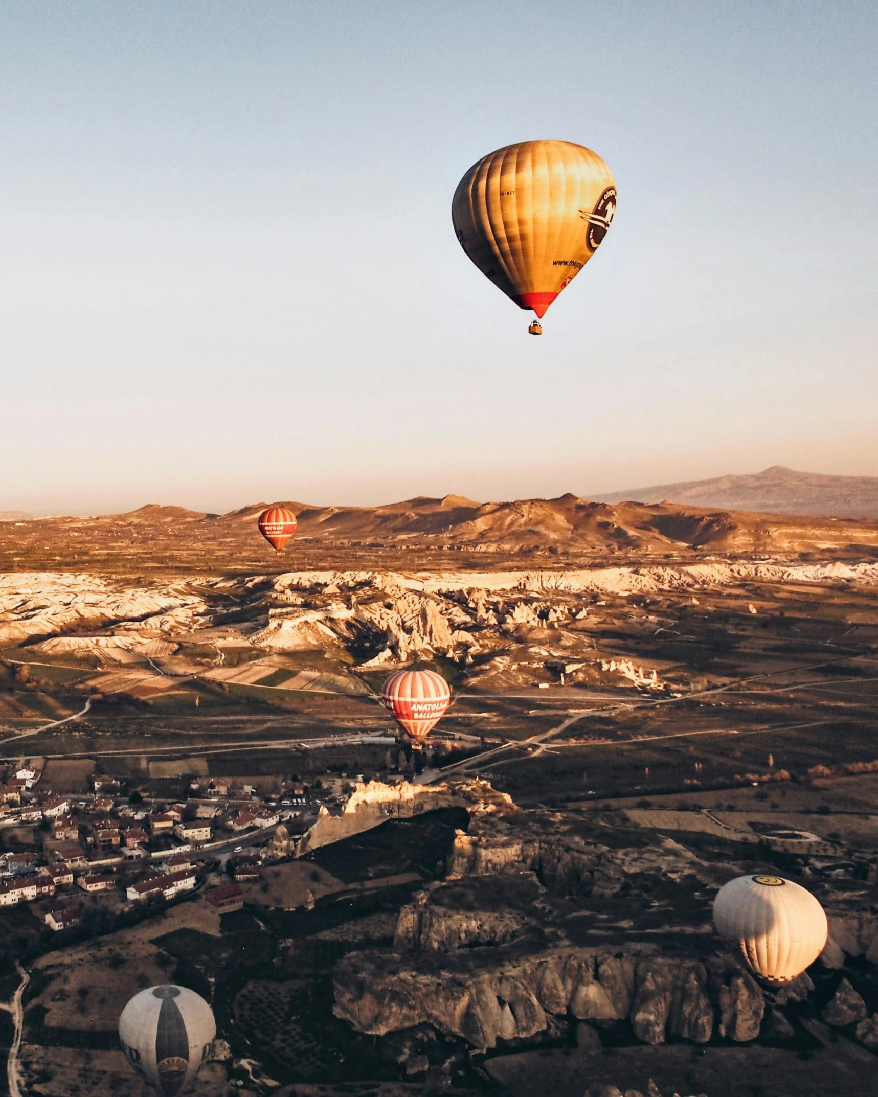  air balloons fly over a scenic city below