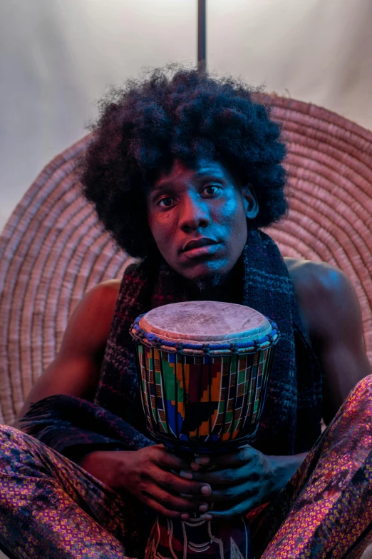 a person sitting on the ground with a drum