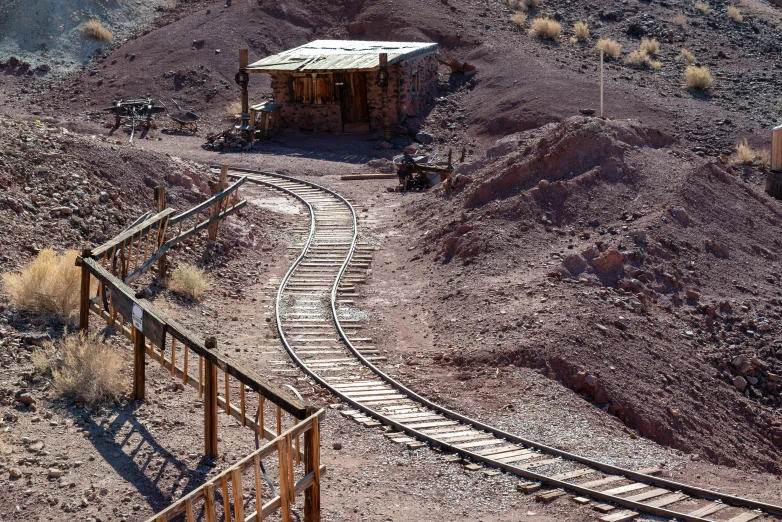 there is a train crossing the tracks into the mountain