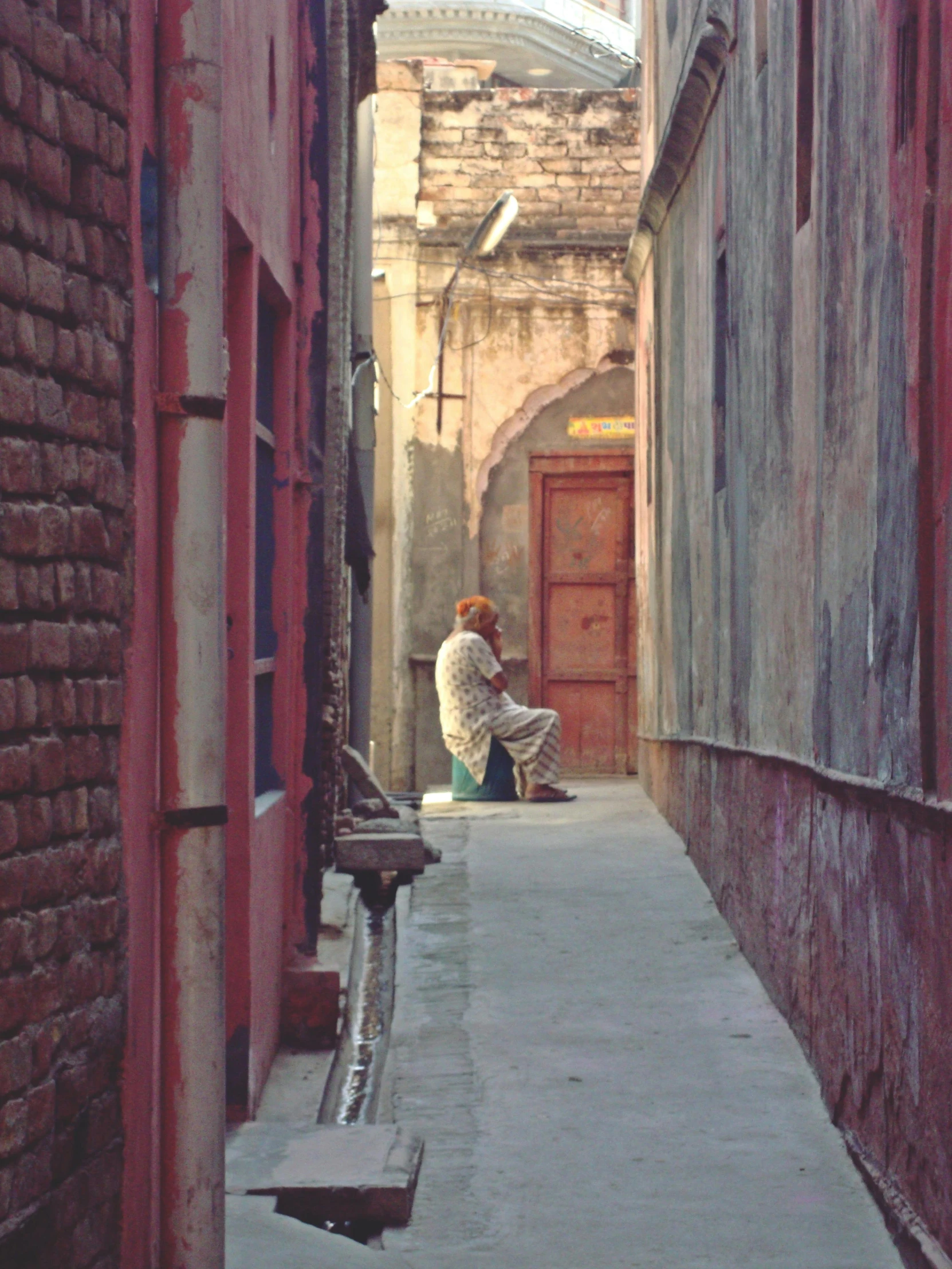 a man sitting on a bench next to a wall