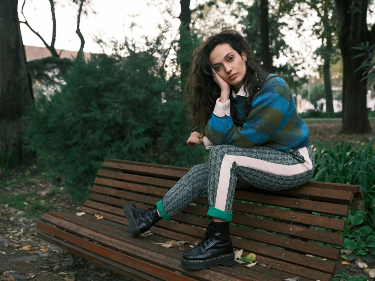 a woman with long hair is sitting on a bench