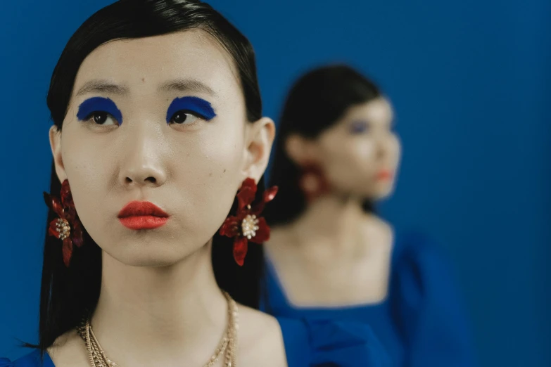 woman wearing bright blue lipstick and matching accessories