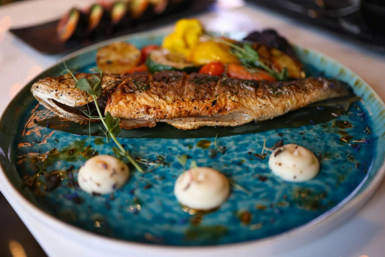 a dish made of fish with fresh vegetables and spices on it