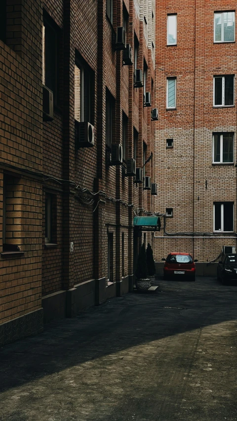 a couple of cars parked next to a tall brick building