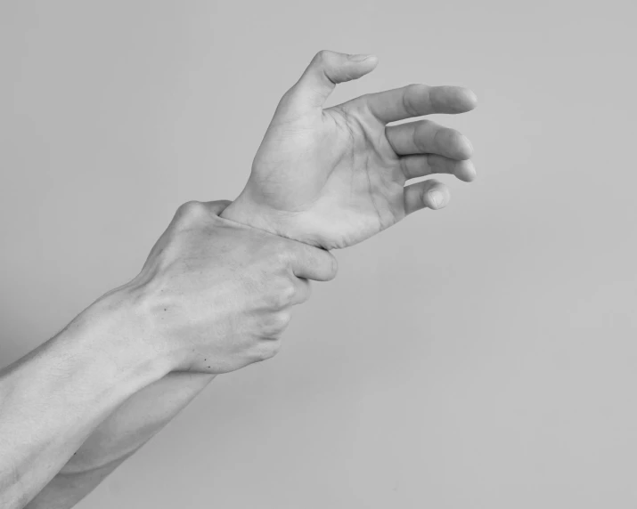 an upclose view of a person's arm with a hand holding the wrist of someone