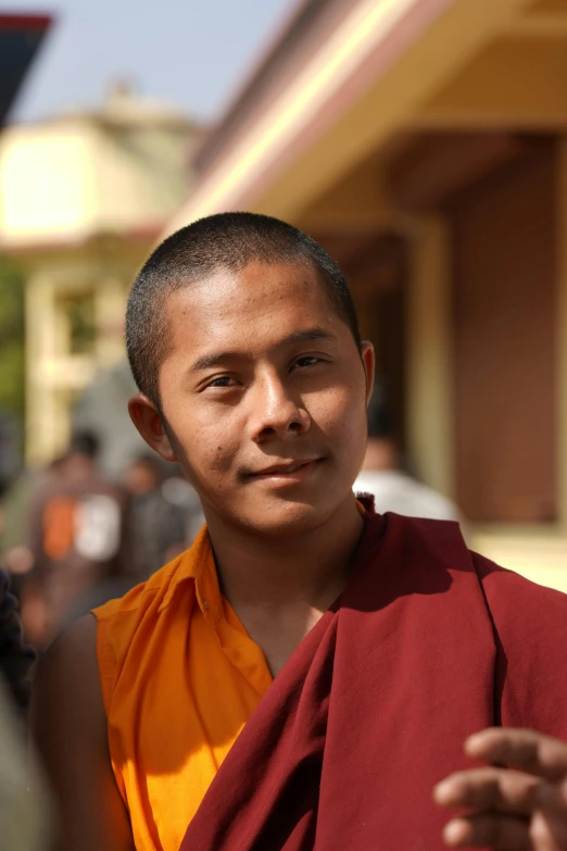 a monk in orange shirt sitting next to a woman