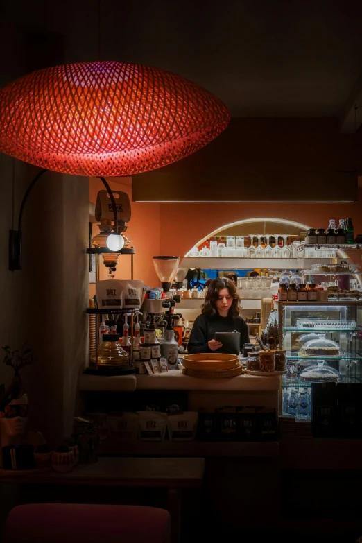 a woman behind the counter is looking into a kitchen