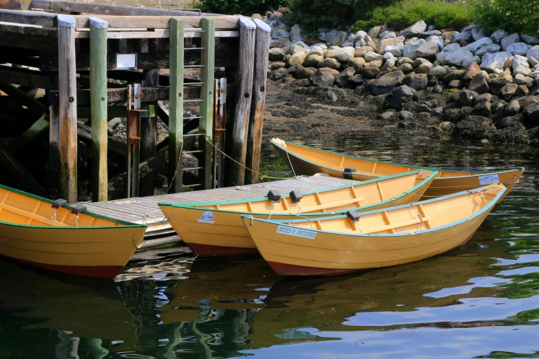 three small yellow boats are in the water