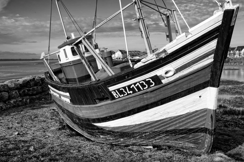 the large boat is parked on the sand next to the water