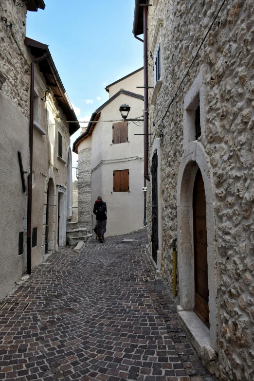 a narrow cobblestone street with an old fashion building