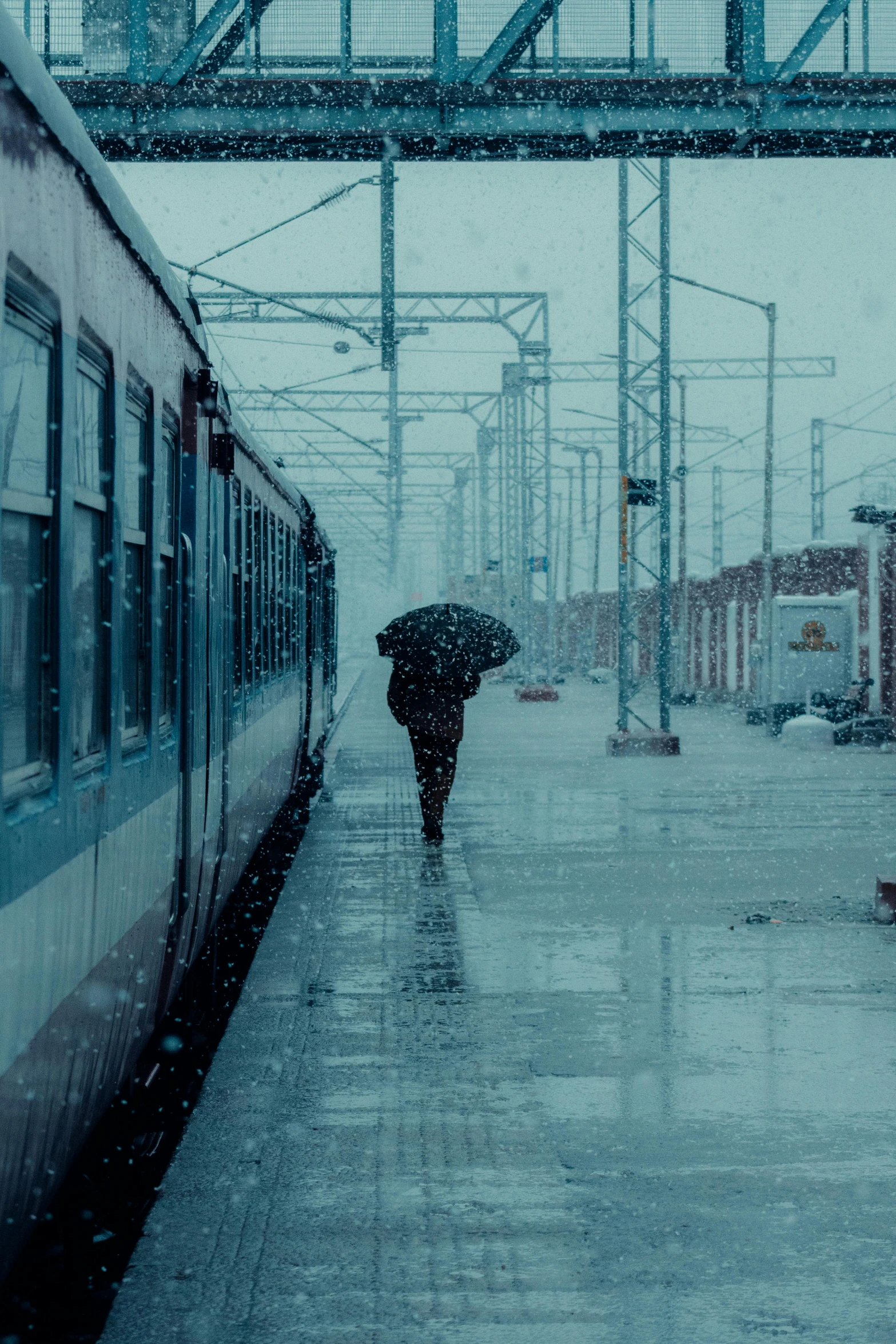 people walking down a wet sidewalk with an umbrella