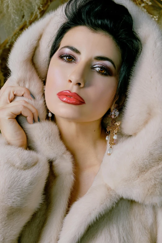 a woman wearing a white fur coat with beads