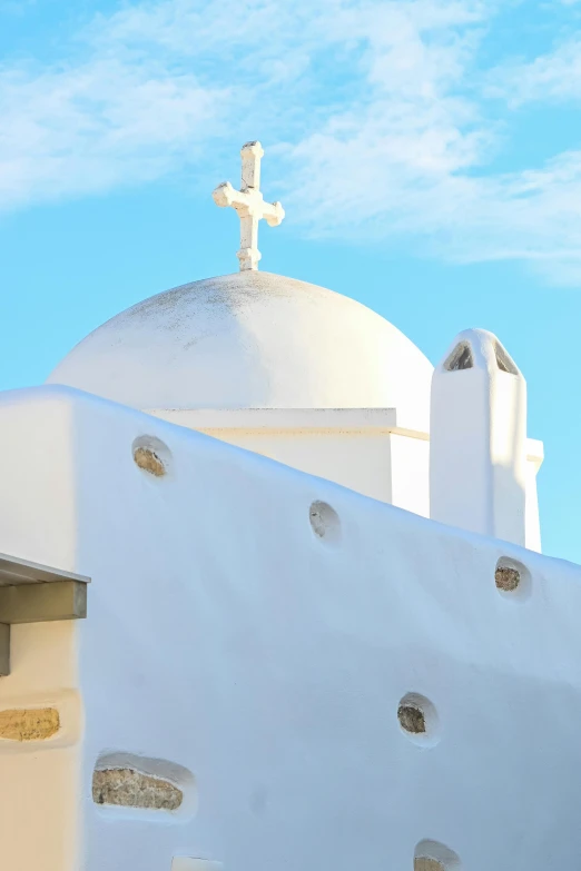 a tall white church with a cross at the top