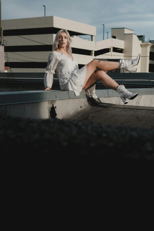 a woman sitting down wearing white on her knees