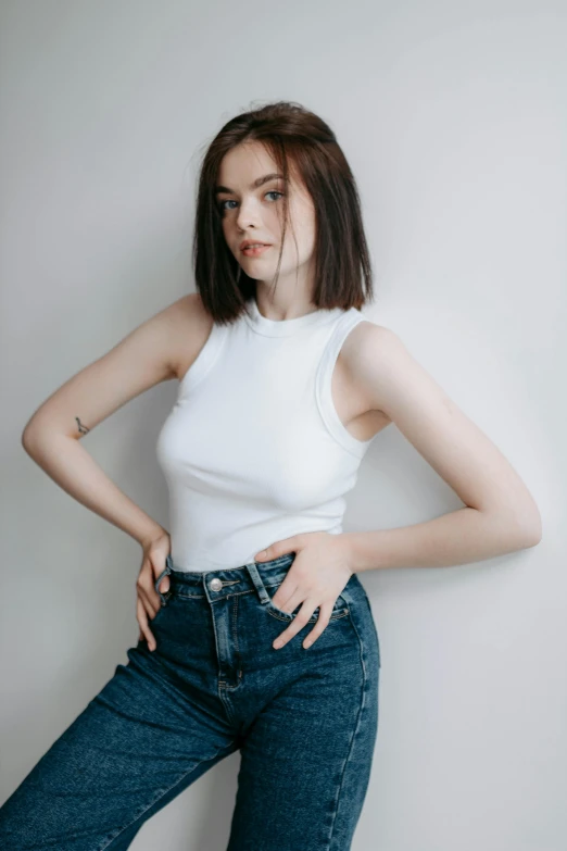 a girl in jeans and a white shirt posing for the camera