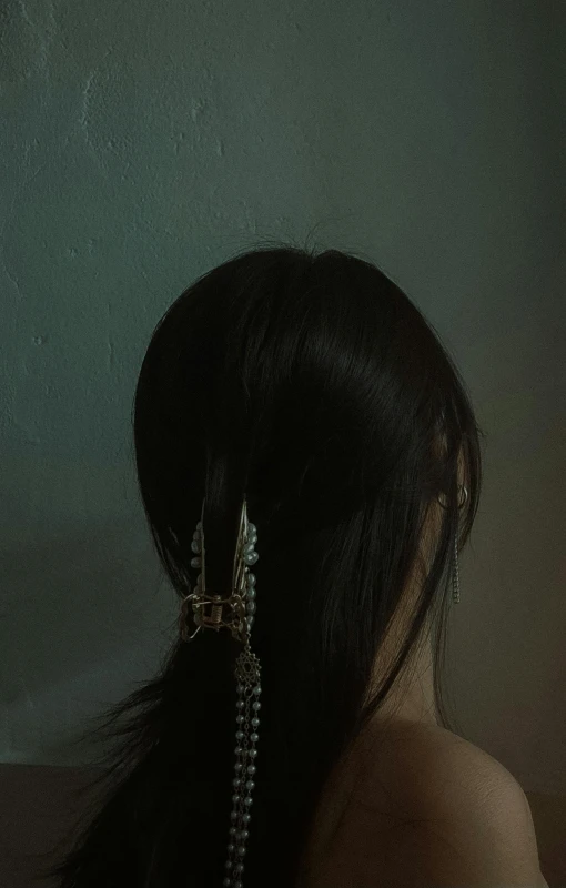 a woman wearing an elaborate ear chain and hair comb