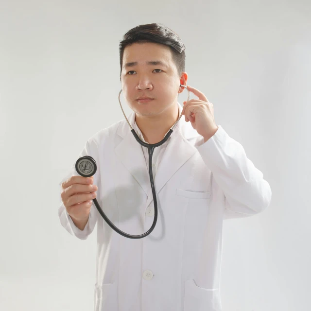 man holding stethoscope to ear with one hand