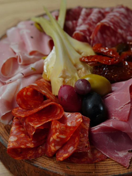 a bowl with meat and olives is on a table