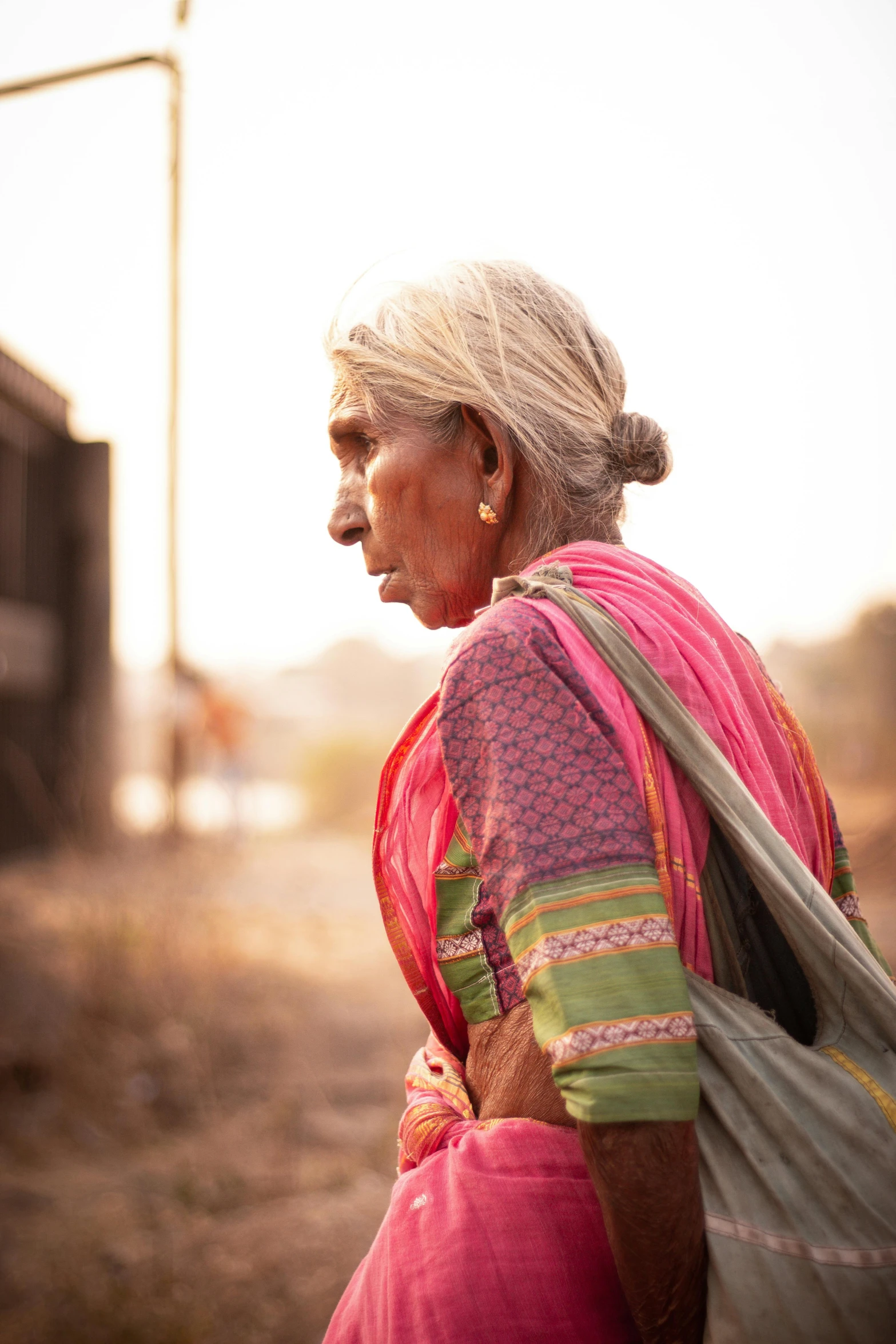 an elderly woman in an indian dress walking