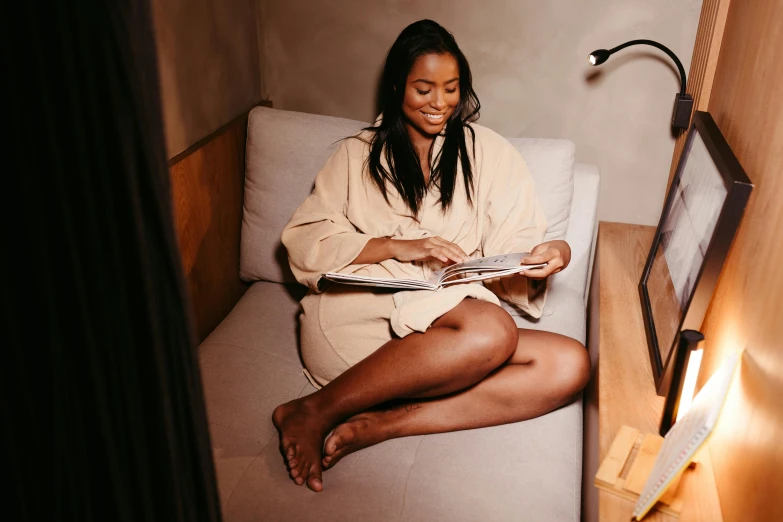 the young woman is reading her book in the small room