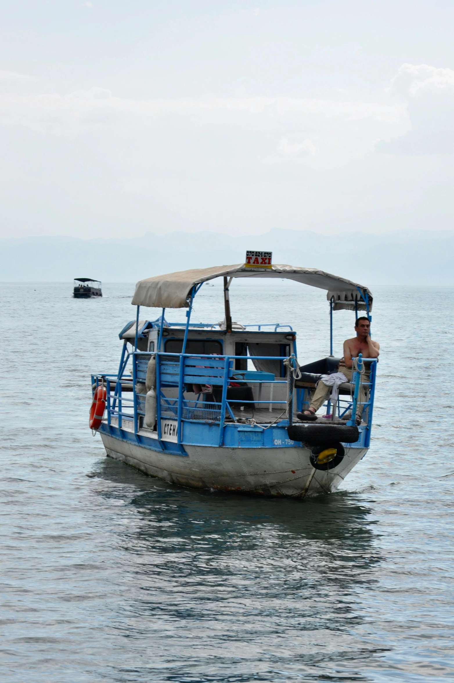 a ferry boat sails through the water near a small ship