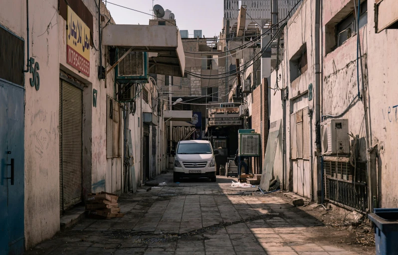 a white van parked on the street between buildings