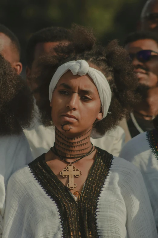 a woman with cross shaped jewelry looking at camera