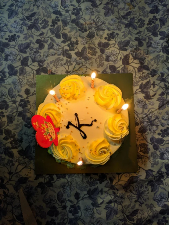 a cake on a green plate decorated with yellow frosting roses