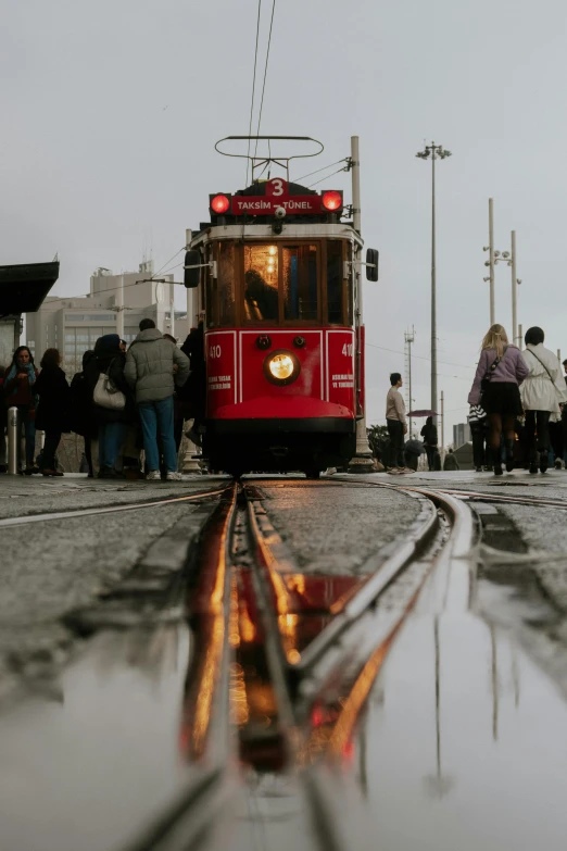 people walking by a train at a cross walk