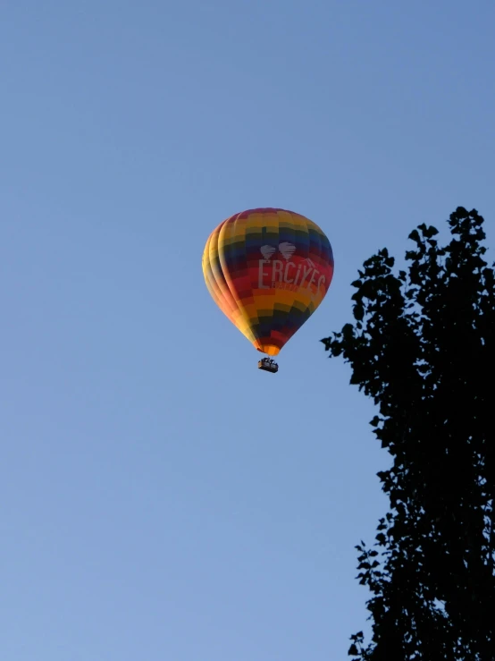 a large  air balloon with words painted on it flying in the sky