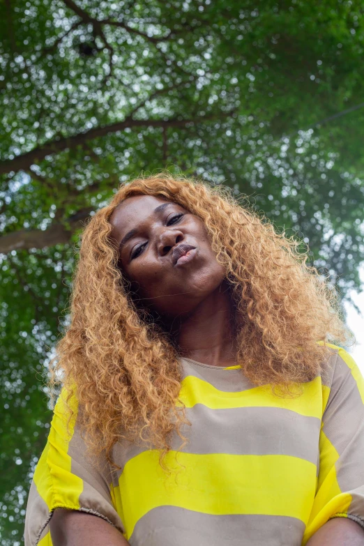 a red headed woman with long hair wearing a yellow and grey striped shirt