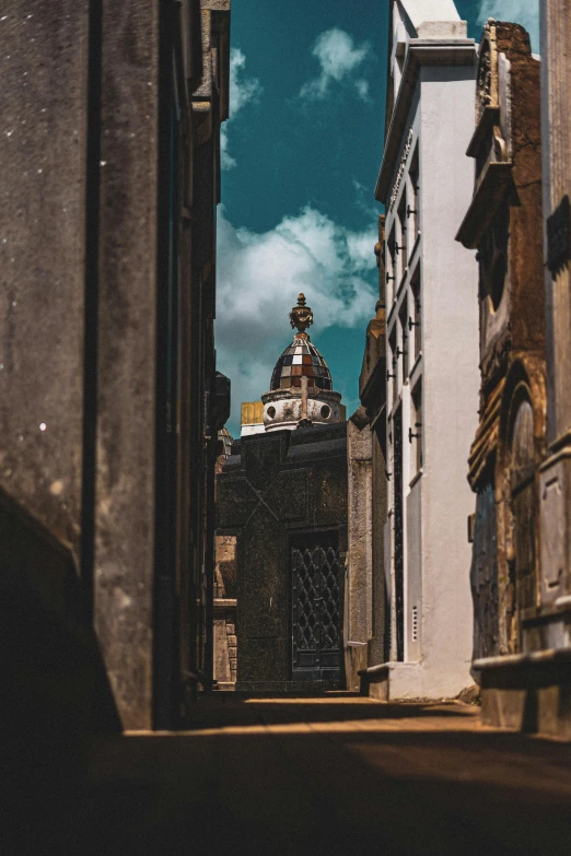 an alley way between buildings with a dome