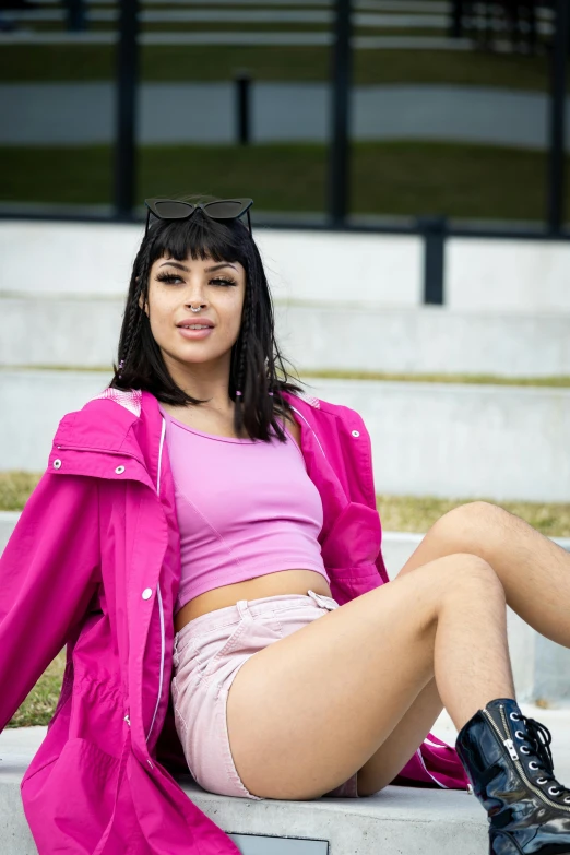 a woman in a pink top is sitting on stairs