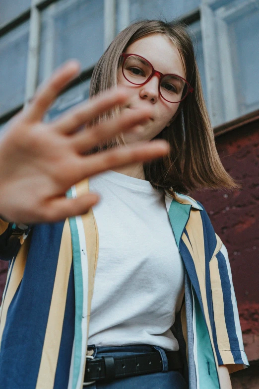 woman with glasses making vulcan hand gesture