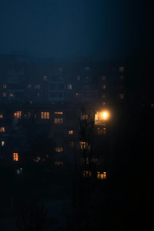 a city skyline at night with an overcast sky