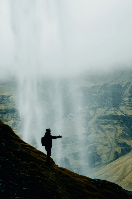 a man on top of a hill looking at the sky