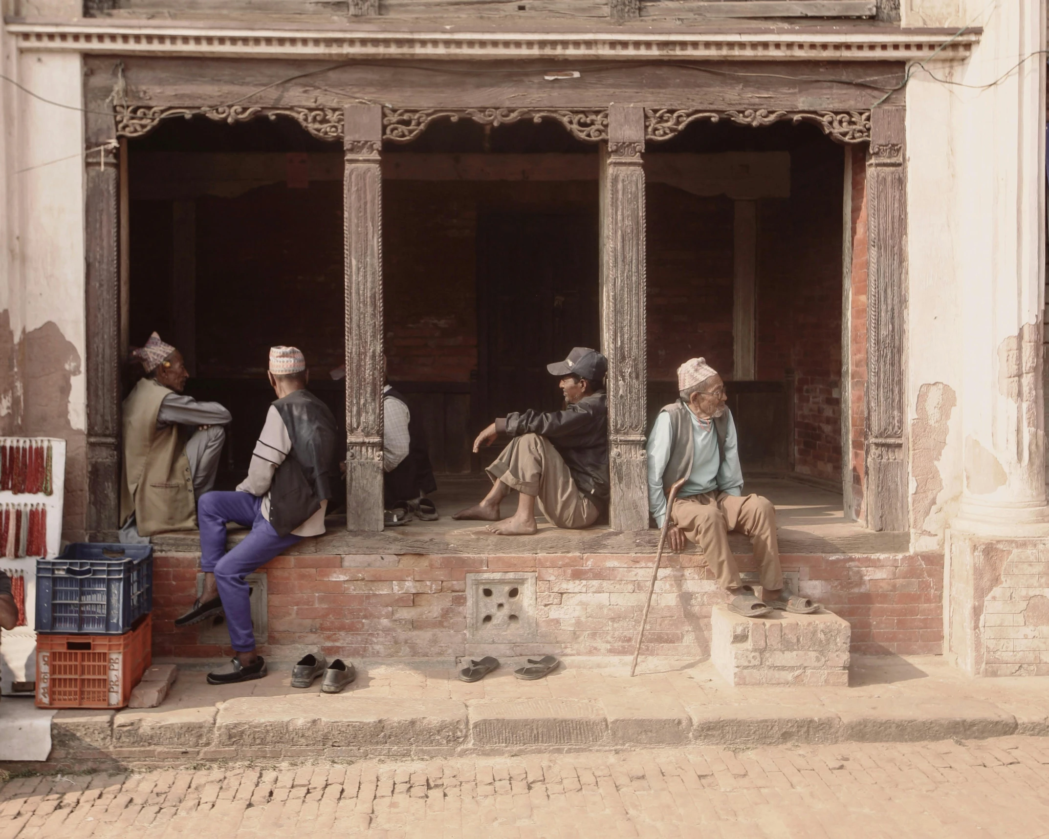 men sitting in front of an old brick building