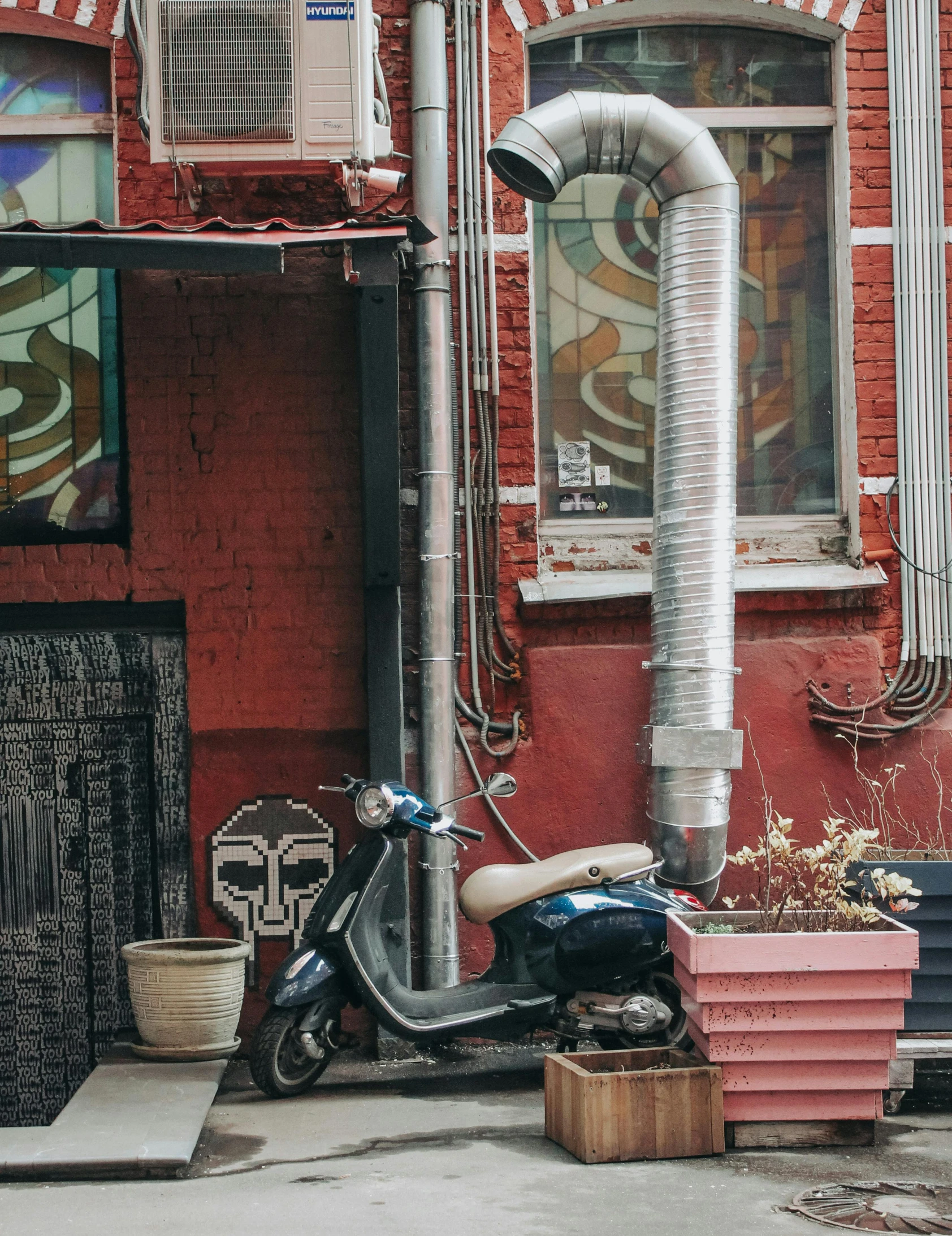 the back wall of a building with a scooter parked near it