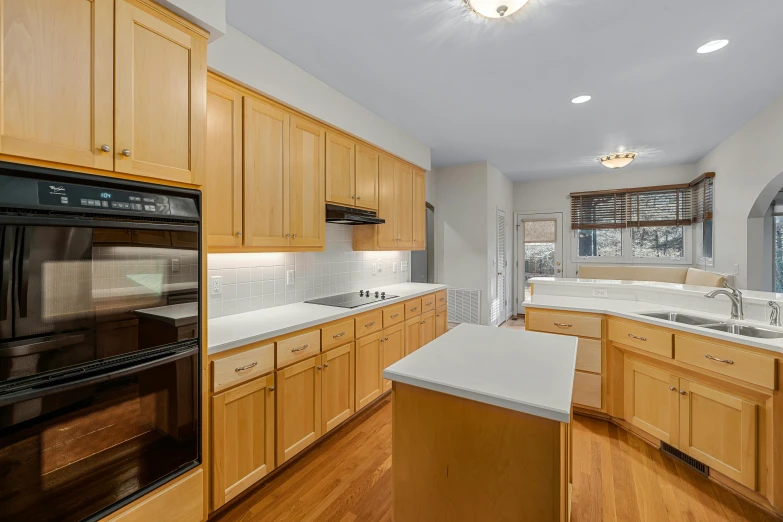 a modern kitchen with hardwood floors, white counters and a stove