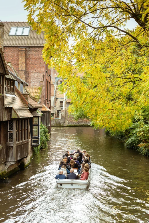 a group of people in a boat riding on a canal