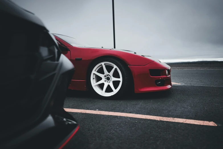 red sports car parked in front of another car