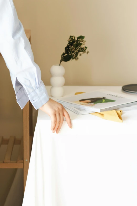 someone reaching their hand on the table to put soing in a book