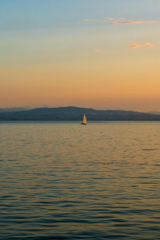 sailboat in the ocean with a backdrop of mountains