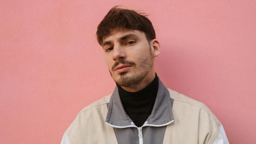 a man with a mustache and white jacket poses for the camera