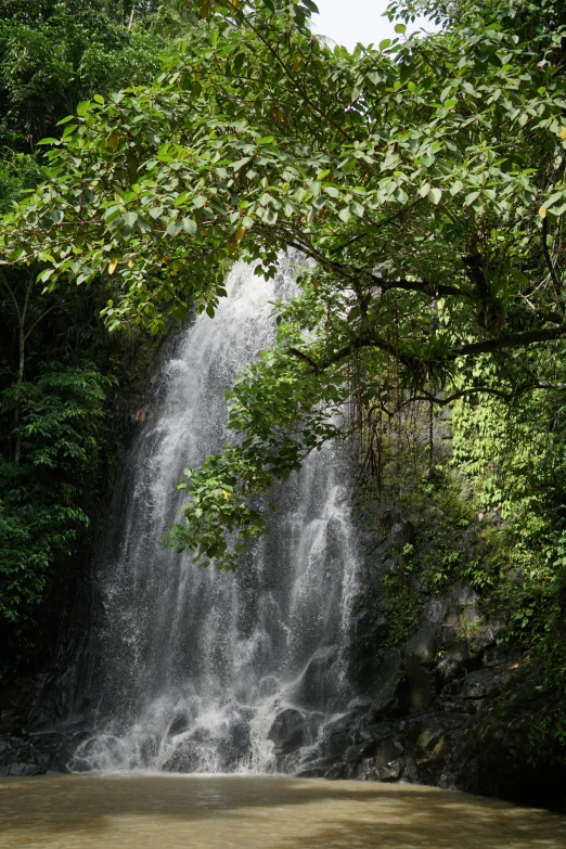 a group of people riding on the back of a boat under a waterfall