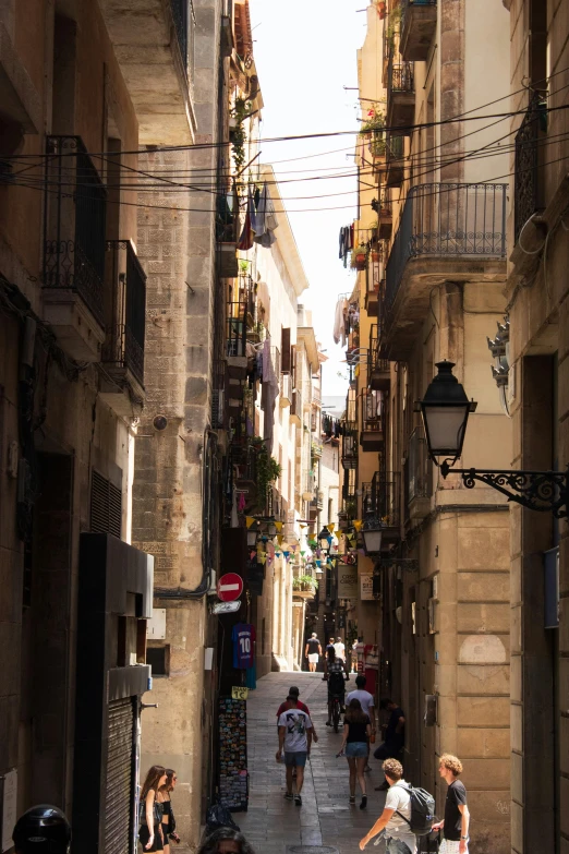 people walking down an alley way in the middle of city