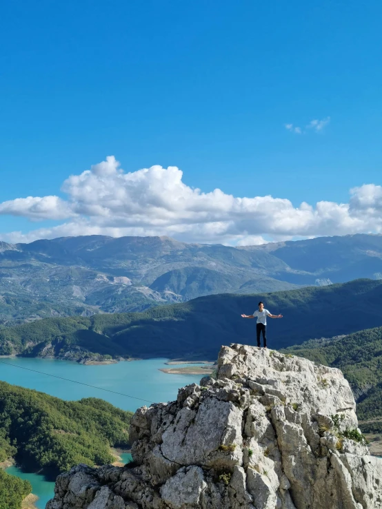 person standing on top of a mountain overlooking water