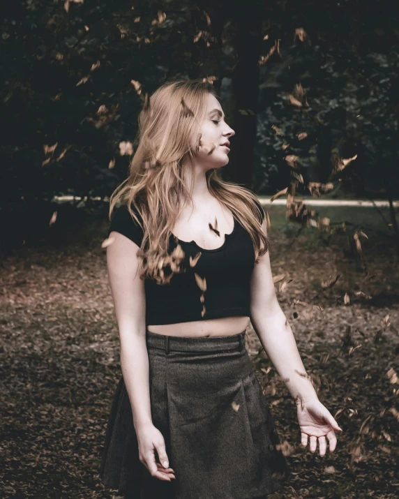 a young lady with a half crop top and short skirt posing for the camera